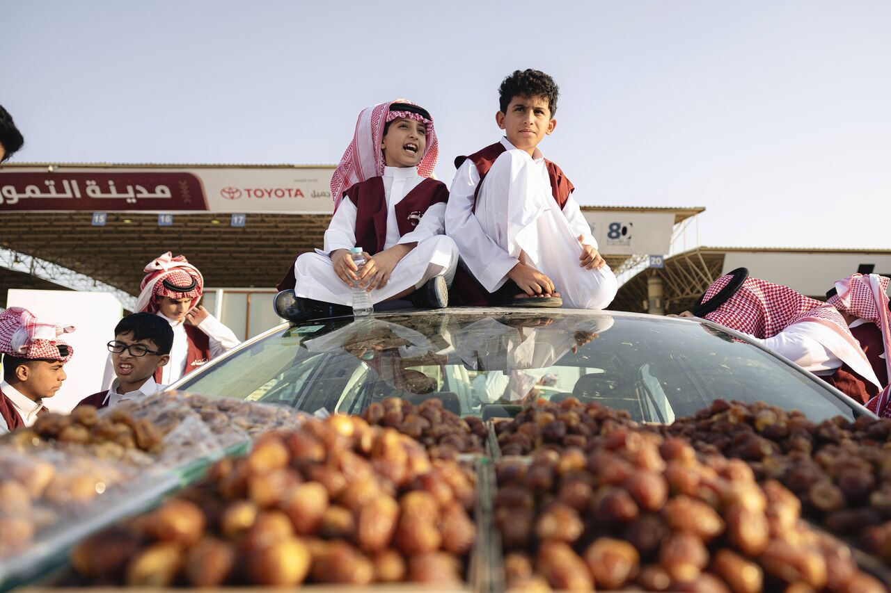طالبان فوق سيارة محملة بالتمر في مزاد مدينة التمور ببريدة